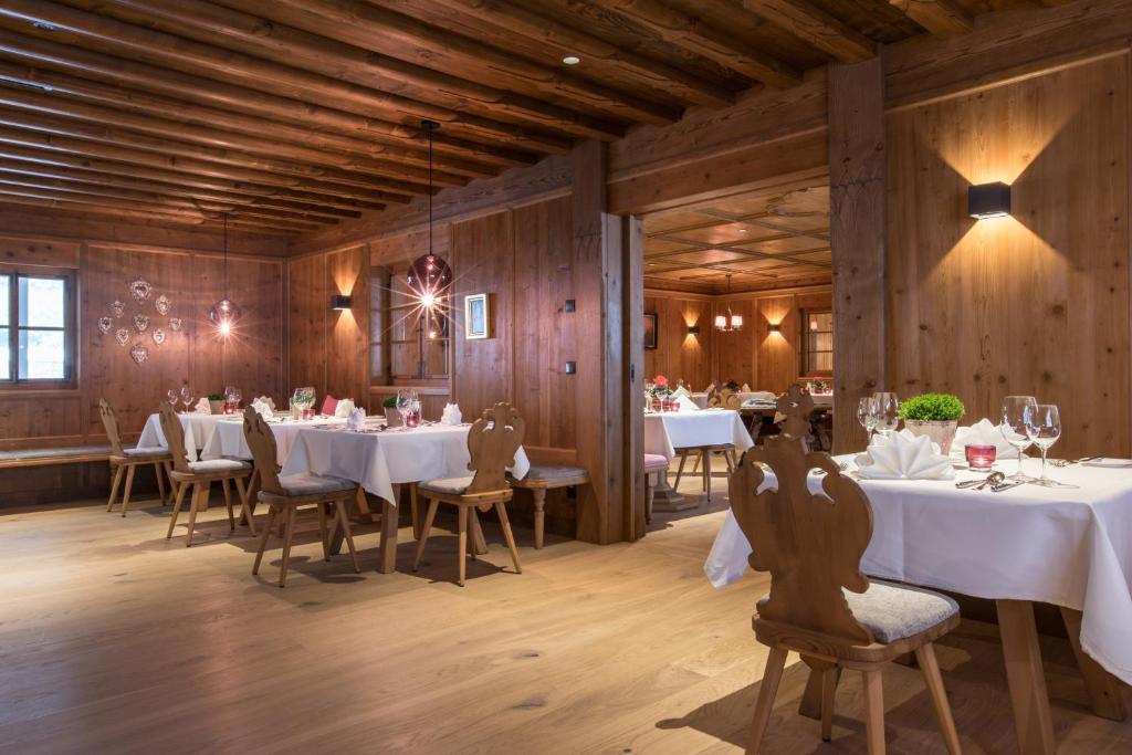a dining room with white tables and chairs and wooden walls at ElisabethHotel Premium Private Retreat- Adults only in Mayrhofen