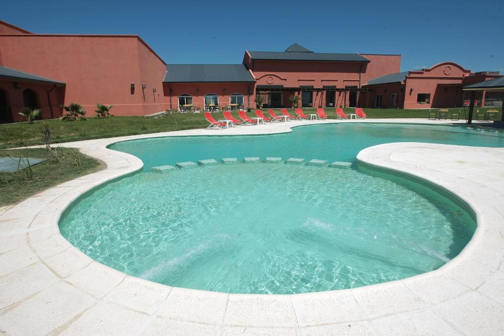 une grande piscine avec des chaises et un bâtiment dans l'établissement Nawan Resort Serrano, à Jesús María