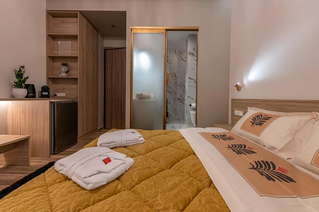 a bedroom with a large bed with towels on it at Psyche & Eros Mythical Suites in Athens