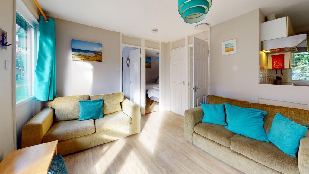 un soggiorno con 2 divani e cuscini blu di 31 Trevithick Court, Tolroy Manor a Hayle