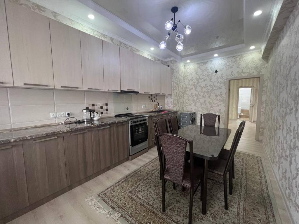 a kitchen with a table and chairs in a room at 3-room apartment on Baytik-Baatyr 37 in Bishkek