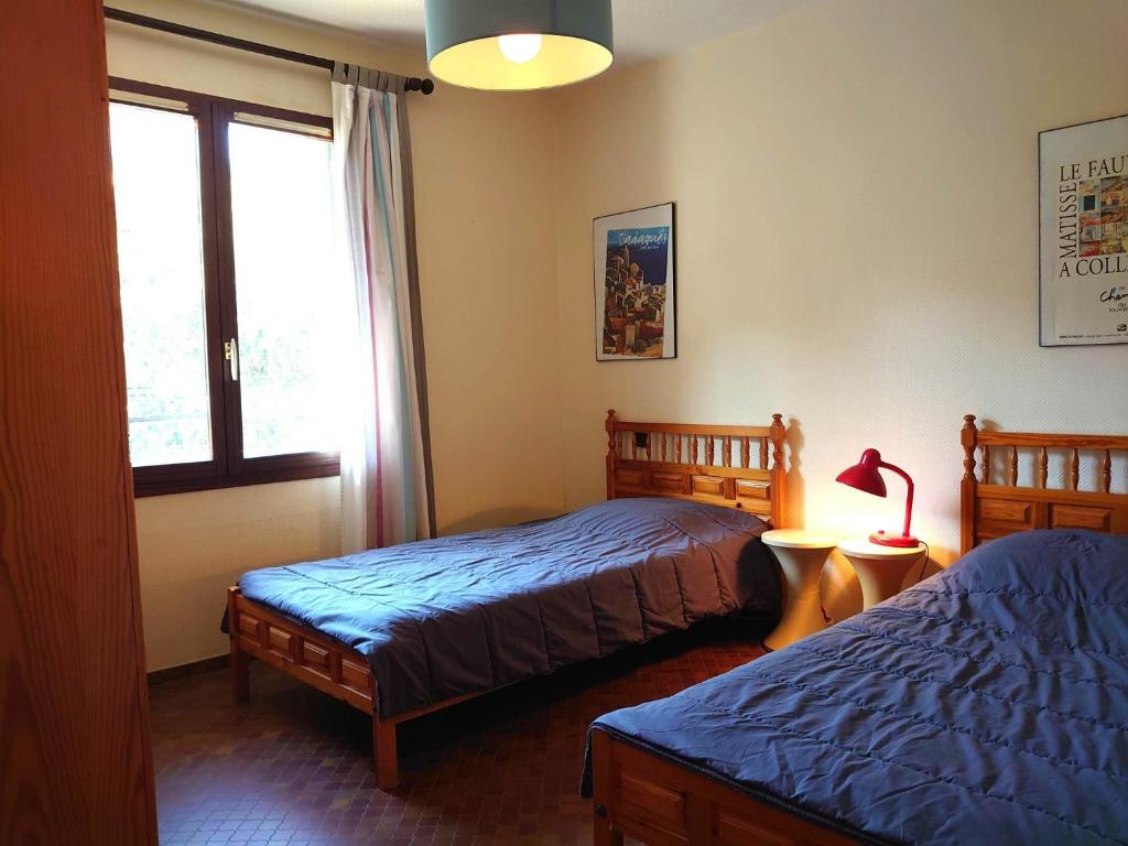 sypialnia z 2 łóżkami i oknem w obiekcie 4PA104 Résidence du Port d'Avall w mieście Collioure