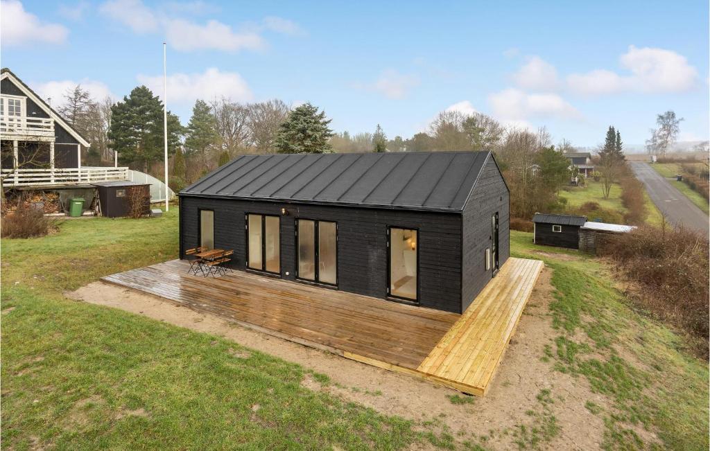 czarny domek z drewnianym tarasem w obiekcie Amazing Home In Vordingborg With Kitchen w mieście Vordingborg