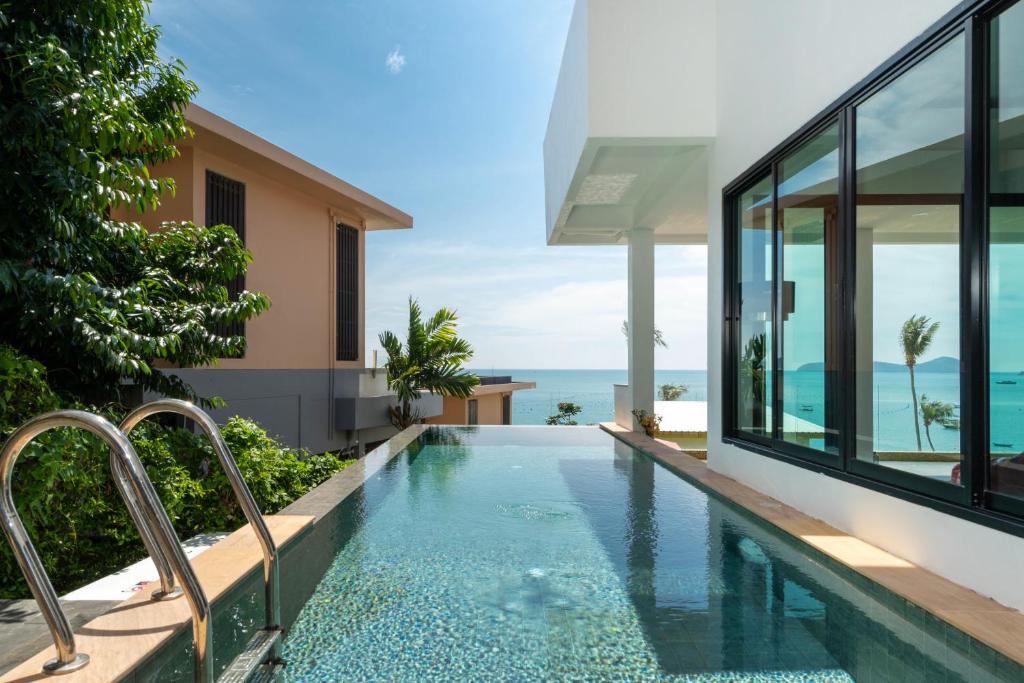 - une piscine à débordement dans une villa avec l'océan en arrière-plan dans l'établissement mona seaview pool villa beach front AoYon Beach, à Ban Ao Makham