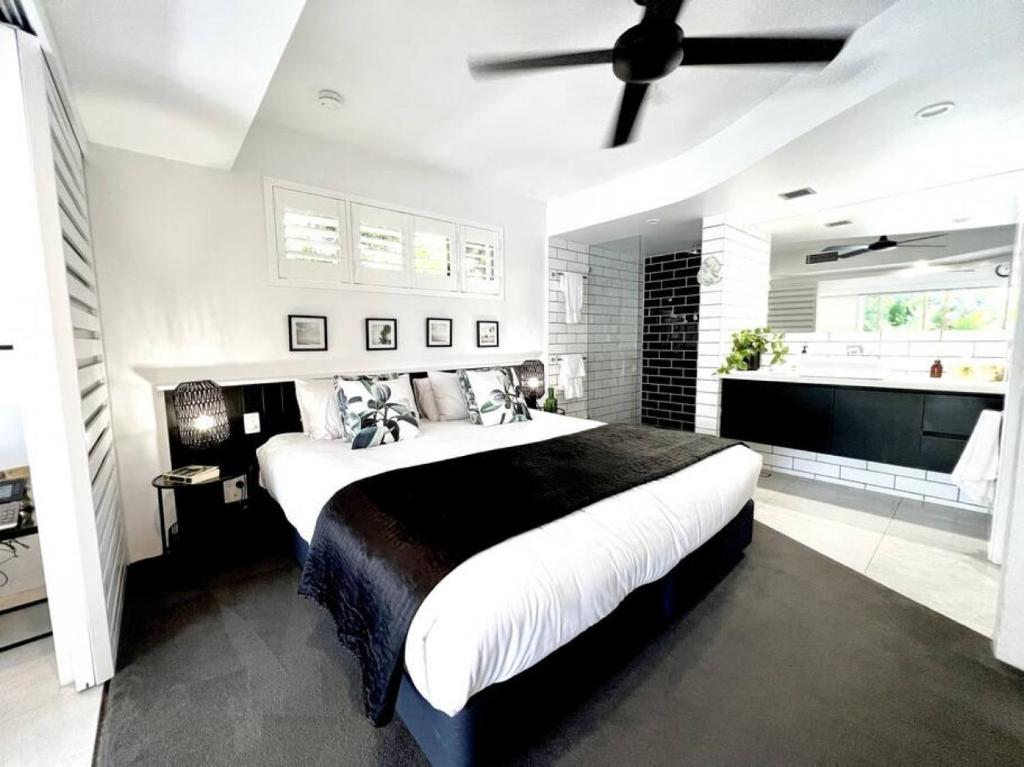 225 2 Bedroom Garden Oasis French Quarter Resort في نوسا هيدز: غرفة نوم بسرير كبير ومروحة سقف