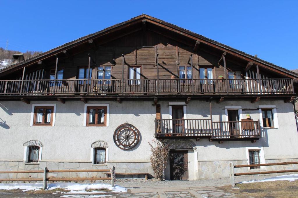 a building with a balcony and a clock on it at Casa Griot in Pragelato