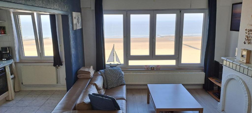 a living room with a couch and a view of the ocean at Appartement Zeedijk Blankenberge - near Brugge in Blankenberge