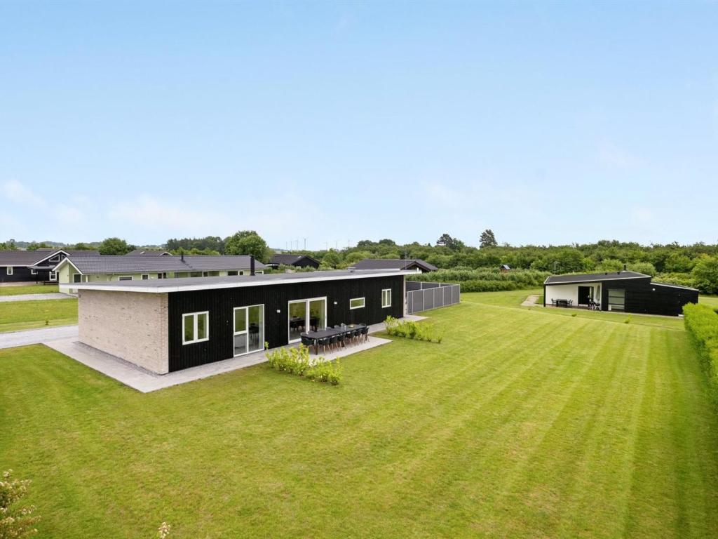 a black house with a large grass yard at Holiday Home Holmsten - 1km from the sea in SE Jutland by Interhome in Neder Lysabild