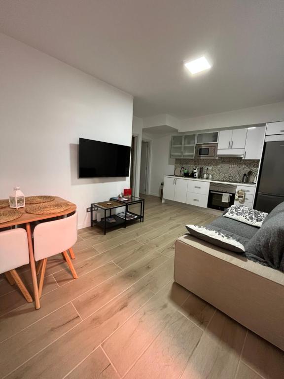 sala de estar con sofá, mesa y cocina en alisios loft, en Las Palmas de Gran Canaria