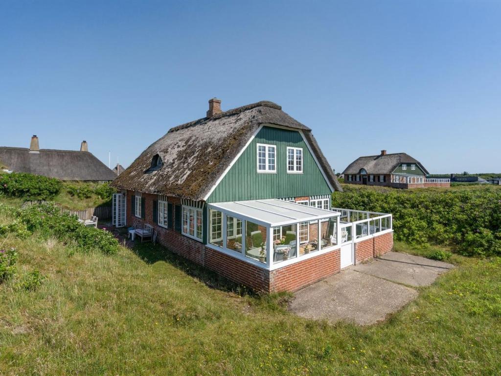 an old house with a thatched roof on a field at Holiday Home Mattias - 100m from the sea in Western Jutland by Interhome in Fanø