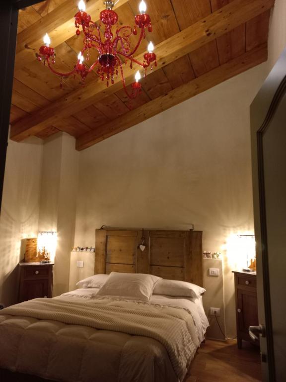 a bedroom with a large bed with a chandelier at BeB montefratta in Fratta Terme