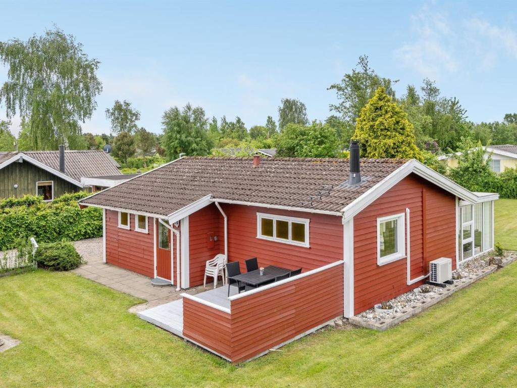 une petite maison rouge avec une arrière-cour dans l'établissement Holiday Home Cenia - 450m from the sea in SE Jutland by Interhome, à Neder Lysabild