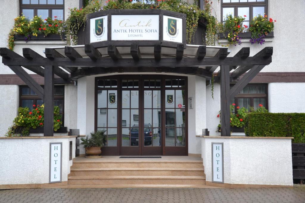 a front entrance to a building with a wooden pergola at Antik Hotel Sofia in Litomyšl