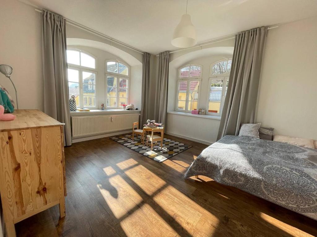 a bedroom with a bed and two windows at Bergblick Apartment Sächsische Schweiz in Sebnitz