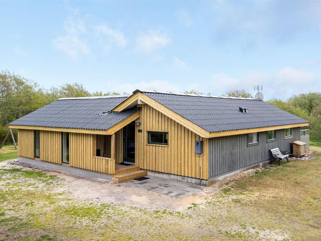 una casa con techo de metal en un campo en Holiday Home Arona - 1-5km from the sea in Western Jutland by Interhome, en Fanø