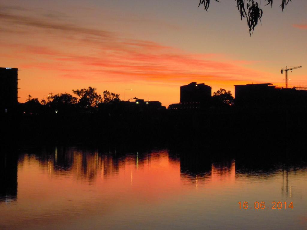 a sunset over a city with a body of water at Riverside Tourist Park in Rockhampton