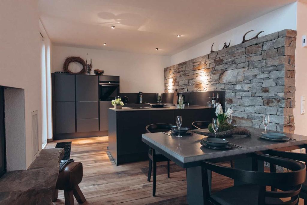 a kitchen with a table and a stone wall at Eifel 2.0 in Bad Münstereifel