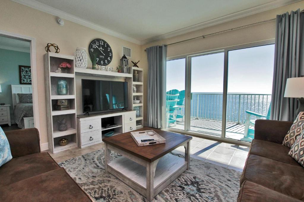 a living room with a couch and a tv and a table at Crystal Shores West 1007 in Gulf Shores