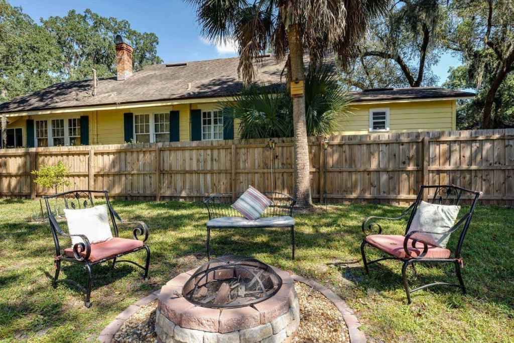 drie stoelen zittend rond een vuurplaats in een tuin bij Bluebird Bungalow in Jacksonville