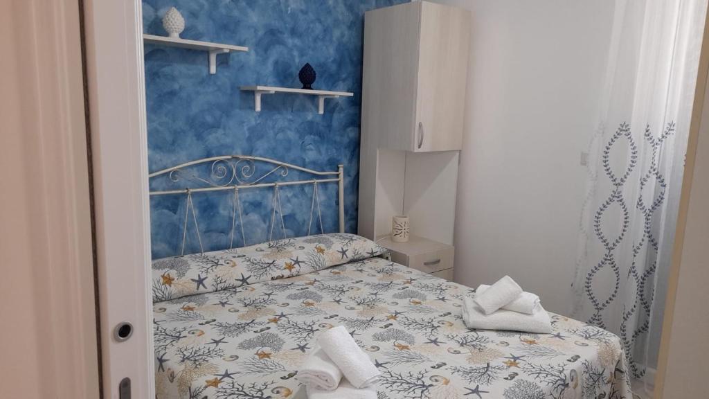 una camera con un letto con una parete blu di Casa Simo a Lido Marini