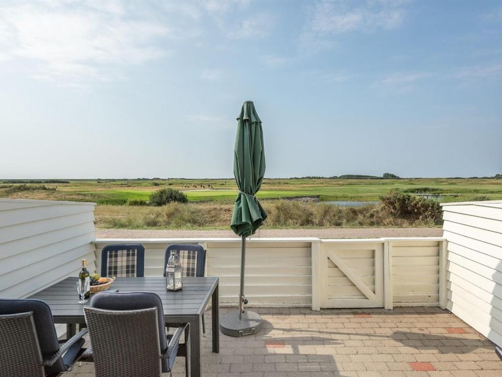 a patio with a table and an umbrella at Apartment Helvig - 2-3km from the sea in Western Jutland by Interhome in Sønderby