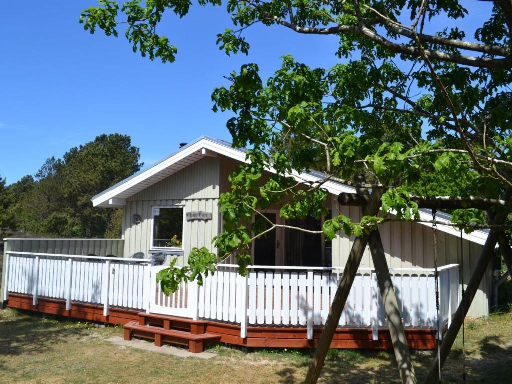 a white cottage with a white fence at Holiday Home Karlotta - 2-2km from the sea in Western Jutland by Interhome in Bolilmark