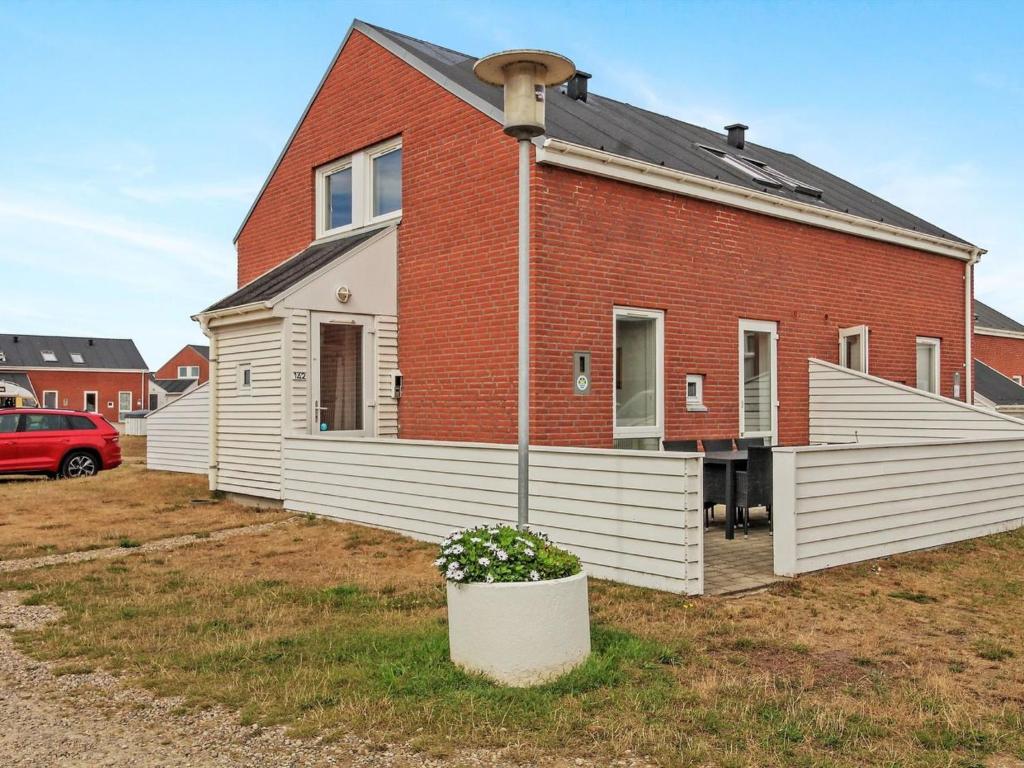 een groot gebouw van rode baksteen met een huis bij Apartment Raine - 2-3km from the sea in Western Jutland by Interhome in Sønderby