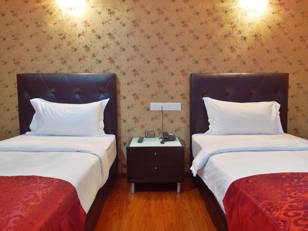 Postel nebo postele na pokoji v ubytování Classic Kinabalu Hotel