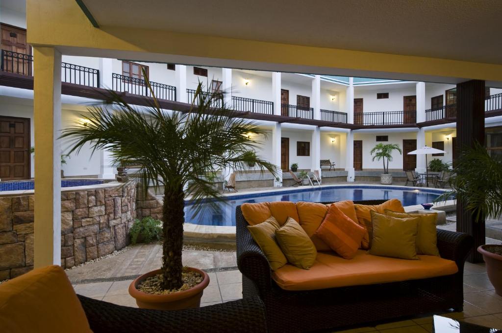 a living room with a couch in front of a pool at Hotel Mozonte in Managua
