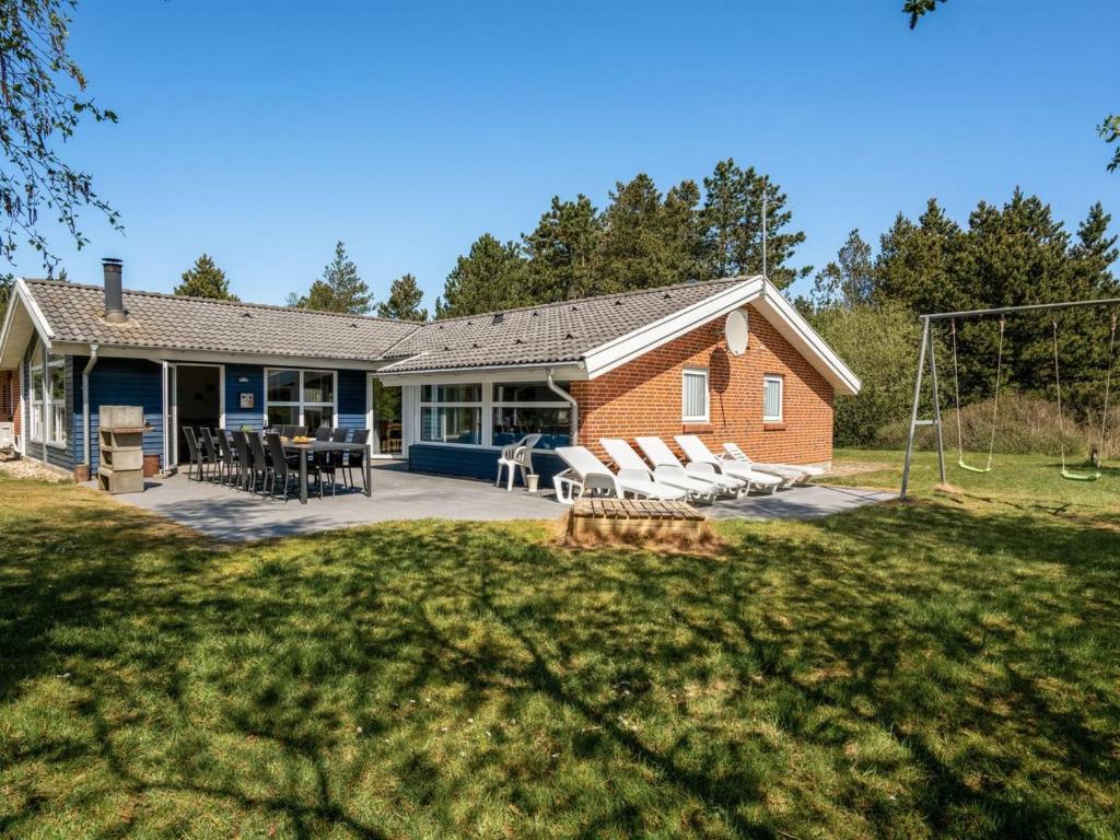 a brick house with a playground at Holiday Home Cordula - 800m from the sea in Western Jutland in Mølby