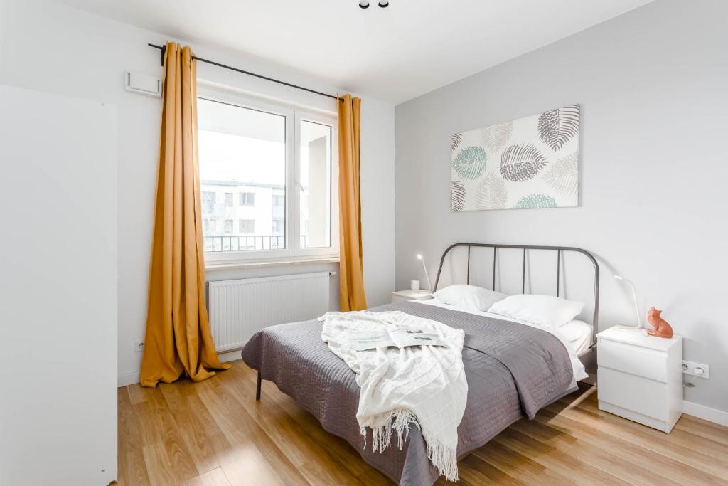 a bedroom with a bed and a large window at Chill Apartments Ursynów in Warsaw
