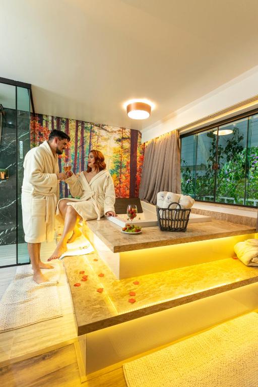 a man and woman in a bath tub in a room at Caminho das Pedras Pousada de Charme in Campos do Jordão