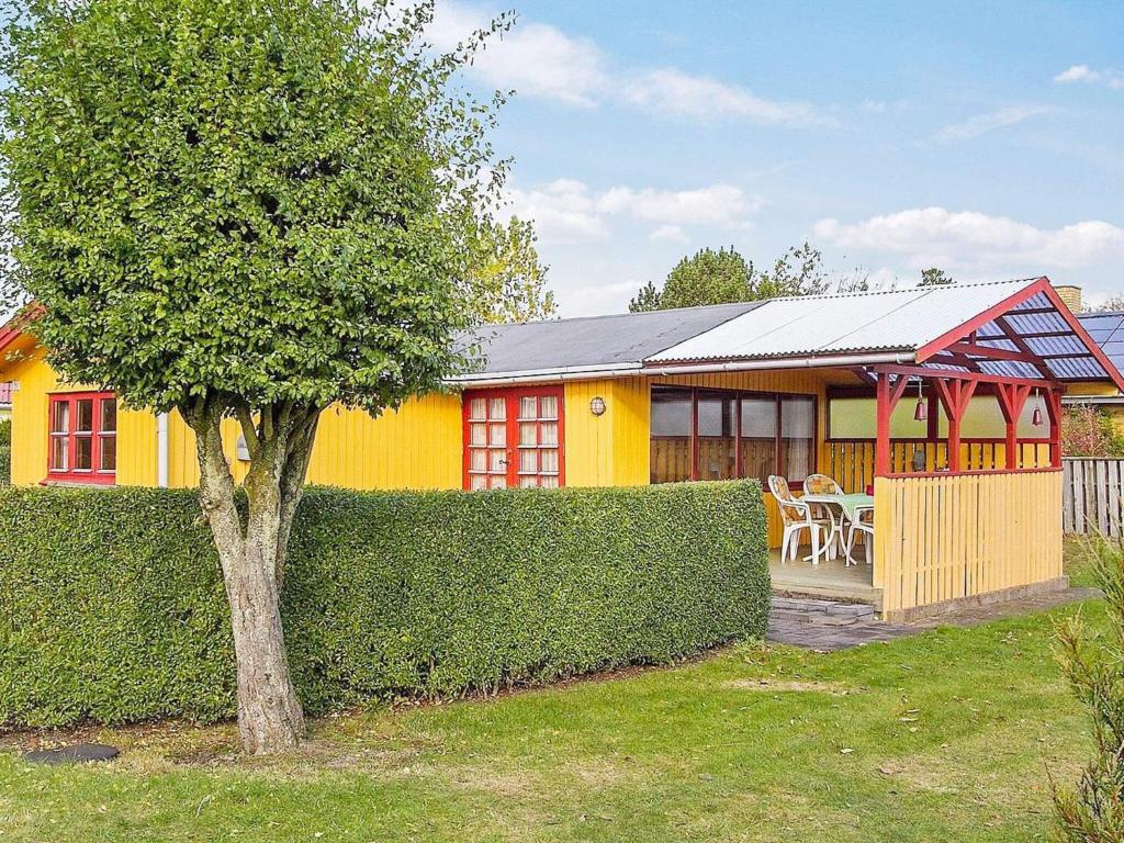 een geel huis met een boom ervoor bij Holiday home Juelsminde XCI in Sønderby