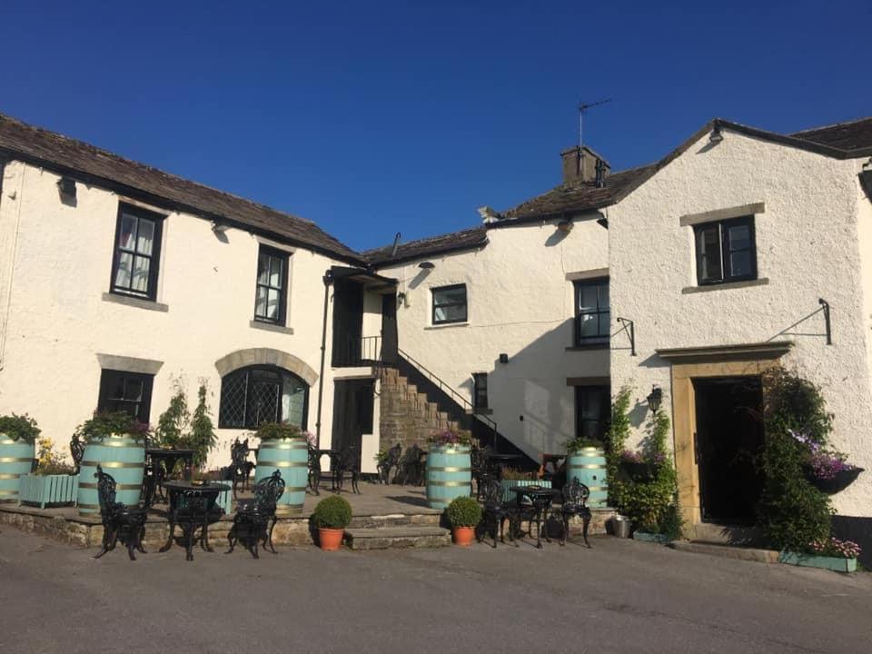 a group of white buildings with tables and chairs at George & Dragon in Aysgarth