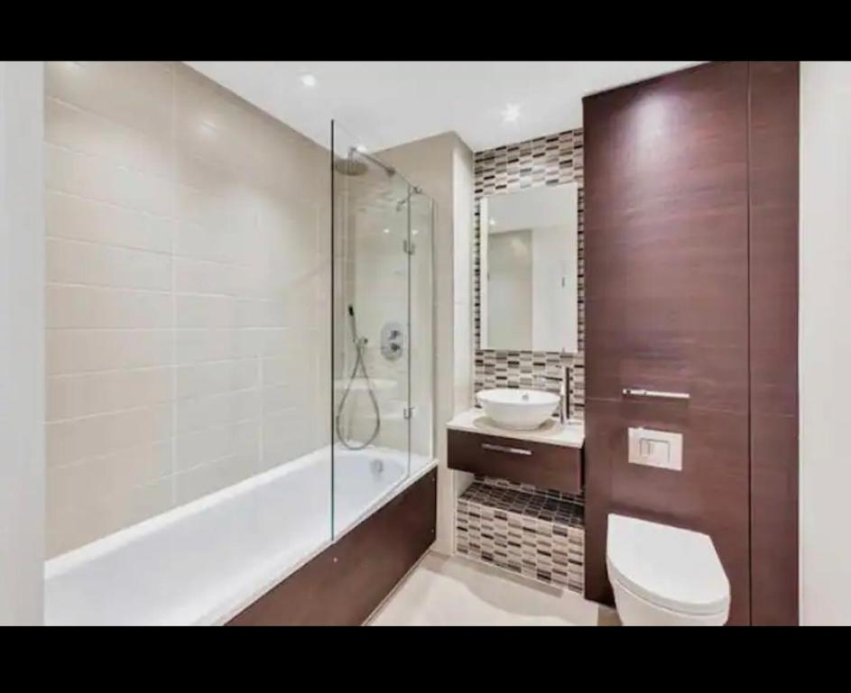 Luxurious 2 bedroom apartment in Canary Wharf في لندن: حمام مع مرحاض ودش ومغسلة