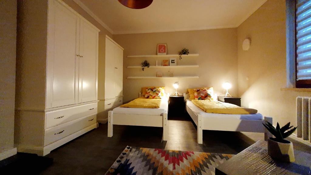 1 dormitorio con 2 camas, armario y alfombra en Ferienwohnung en Kromlau