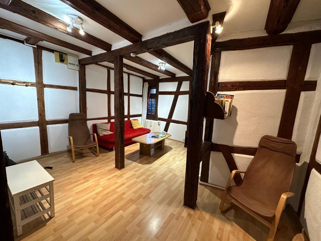 テュルクアイムにあるラ グルヌイユのウッドフロアのリビングルーム(赤いソファ付)