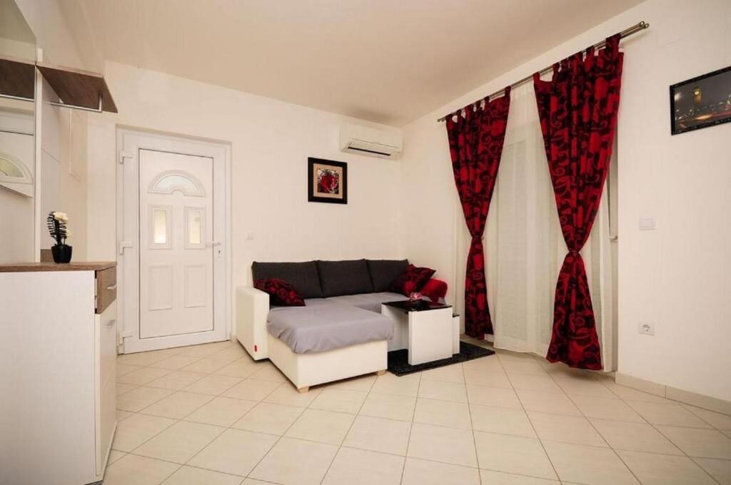 a living room with a couch and red curtains at House Boze in Vinišće