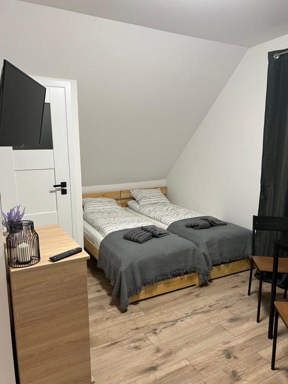 1 Schlafzimmer mit 2 Betten und einem TV an der Wand in der Unterkunft Rzut beretem od gondoli in Szczyrk