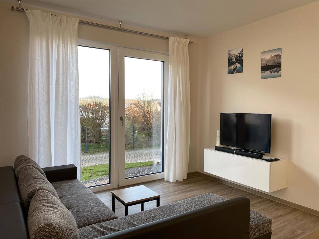 ein Wohnzimmer mit einem Sofa und einem Flachbild-TV in der Unterkunft Moderne Wohnung in Heskem bei Marburg (Lahn) 