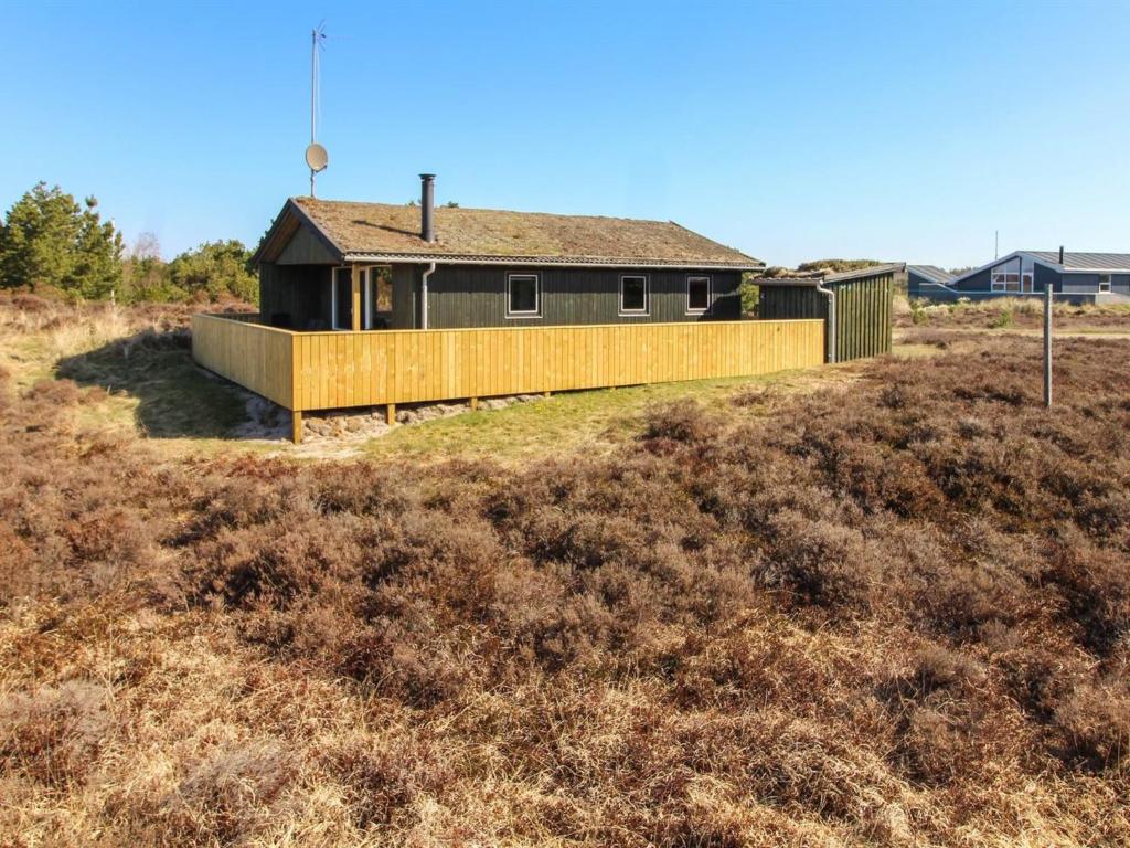 uma casa numa colina com uma cerca de madeira em Holiday Home Sara - 2-5km from the sea in Western Jutland by Interhome em Bolilmark