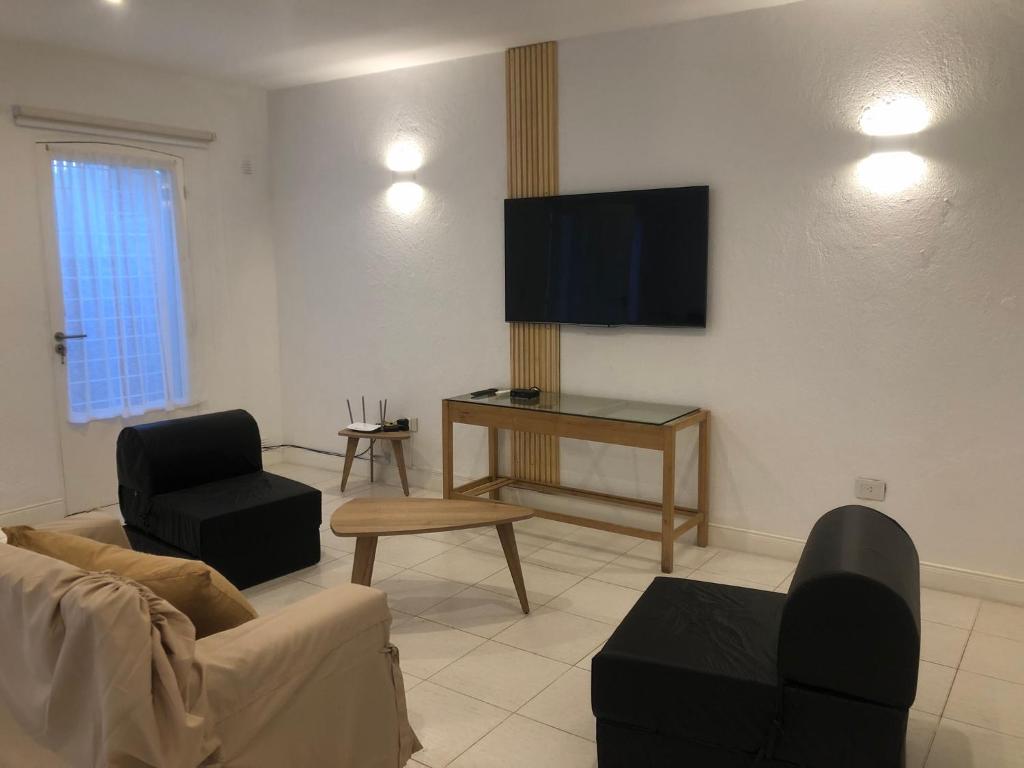 a living room with a couch and a flat screen tv at Casablanca Chacras in Chacras de Coria