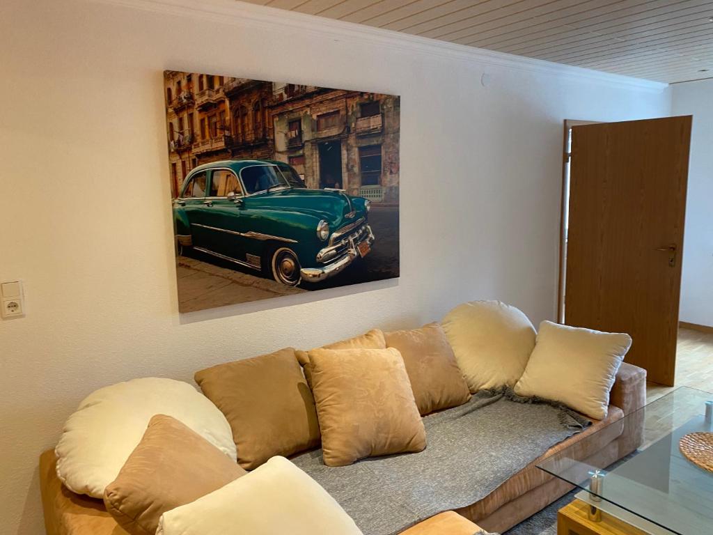 a couch in a living room with a painting of a green car at Ferienhaus-Zirndorf in Zirndorf