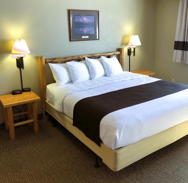 uma cama grande num quarto de hotel com duas lâmpadas em The Antler Lodge - Gardiner em Gardiner