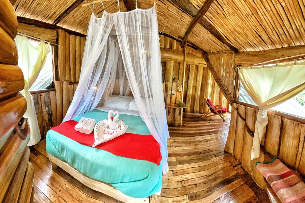 サンタ・テレサにあるEco Quechua Lodgeのログキャビン内のベッドルーム1室
