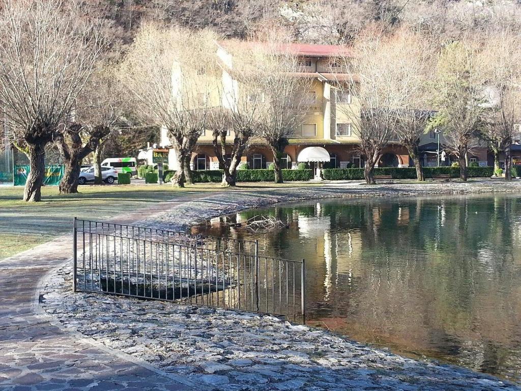 un laghetto con una recinzione di fronte a un edificio di LH Hotel Del Lago Scanno a Scanno