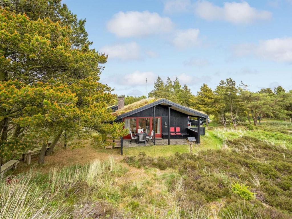 a cabin in the woods with a grass roof at Holiday Home Kathaline - 3-4km from the sea in Western Jutland by Interhome in Bolilmark