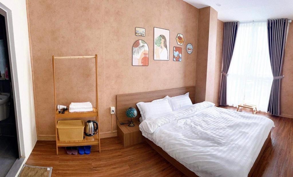 - une chambre avec un lit blanc et une fenêtre dans l'établissement LaLa Homestay, à Hue