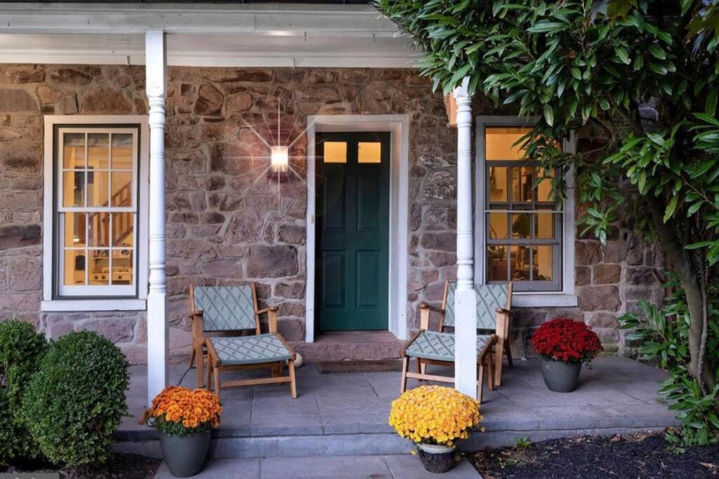 uma casa de pedra com duas cadeiras e uma porta verde em The Stone House on Main Street em Stockton