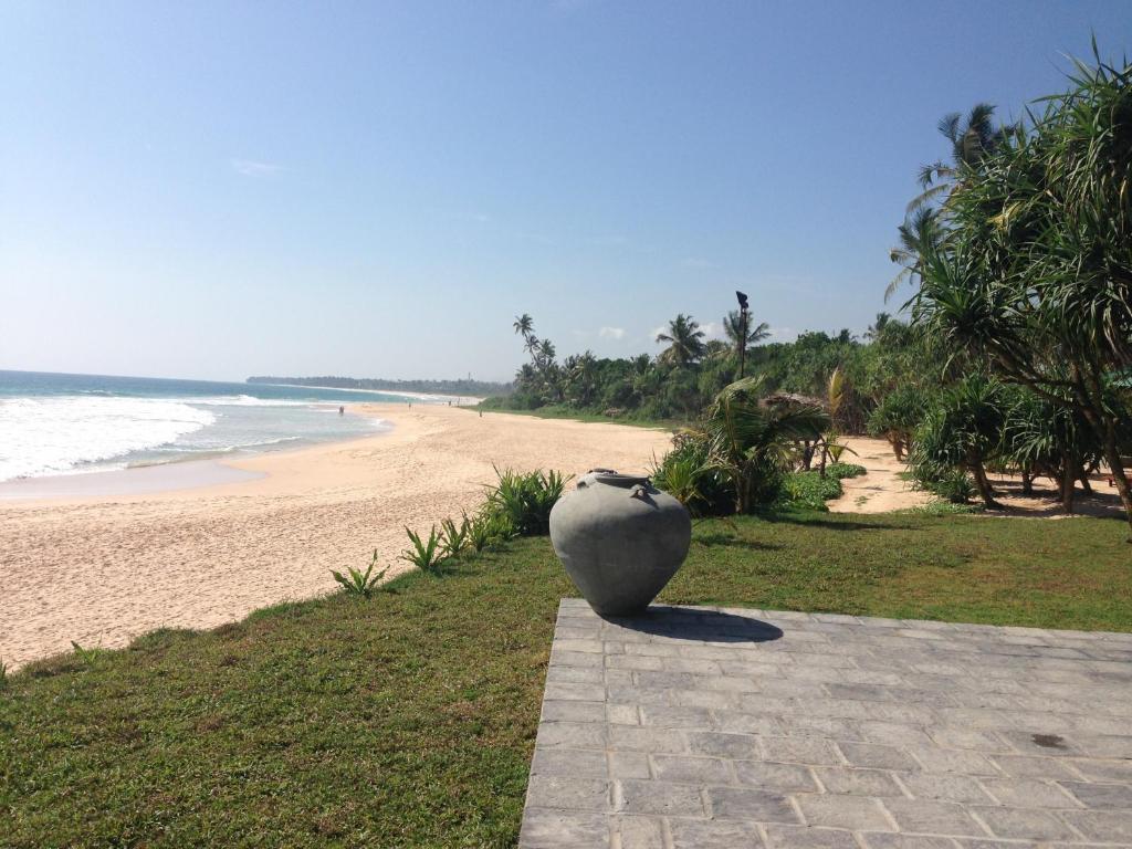 a vase sitting on a sidewalk next to a beach at The Beach Cabanas Retreat & Spa in Koggala